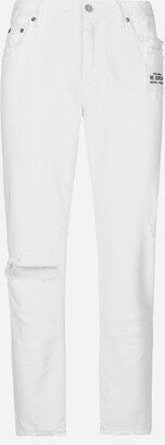 Loose white jeans with rips and abrasions