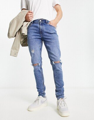 skinny jeans in mid wash blue with rips