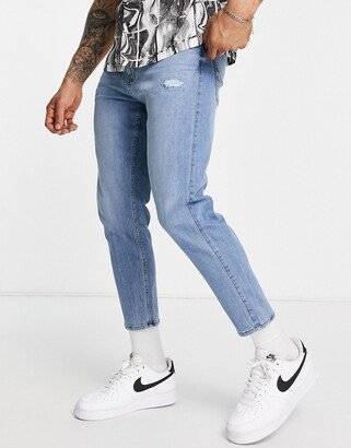 tapered crop fit knee distressed jeans in mid wash