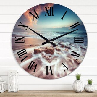 Designart 'Sunrise Over The Beach Waves Washing Stones' Nautical & Coastal wall clock